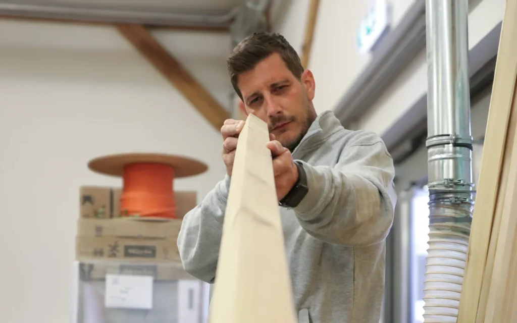 Harald Kraftl prüft Holz in der Werkstatt von Einrichtungsprofi Harald Kraftl in Irnfritz.