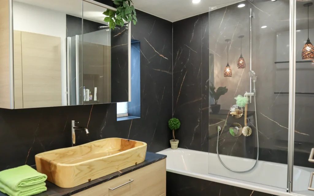 Resopal SpaStyling Bad mit fugenloser Dusche, Badewanne und dunklen Wandpaneelen – umgesetzt im Waldviertel und Weinviertel.