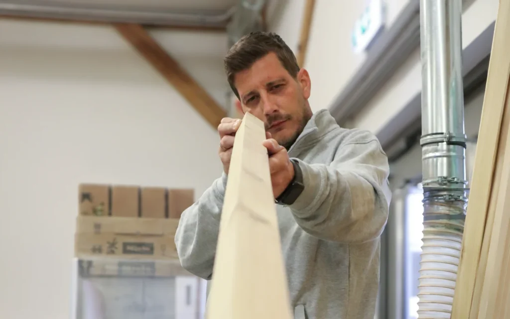 Harald Kraftl prüft Holz in der Werkstatt von Einrichtungsprofi Harald Kraftl in Irnfritz.